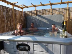 un grupo de personas en una bañera de hidromasaje con vino en B&B Le Corbier, en Herry
