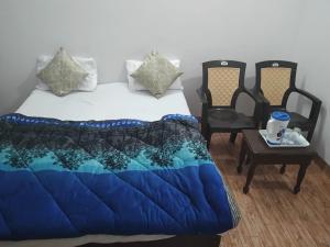 1 dormitorio con 1 cama, mesa y sillas en Shivam Hotel & Restaurant en Khajurāho