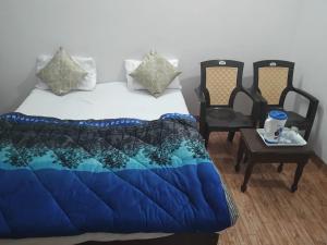 een slaapkamer met een bed en een tafel en stoelen bij Shivam Hotel & Restaurant in Khajurāho