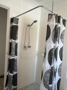 y baño con ducha y cortinas de ducha en blanco y negro. en Humble & Homely, en Rockingham