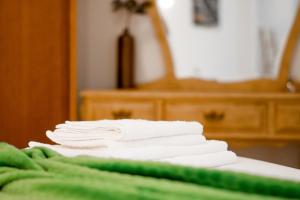 a stack of white towels sitting on top of a bed at Refúgio Nariz do Mundo (Casa do Meio) in Cabeceiras de Basto