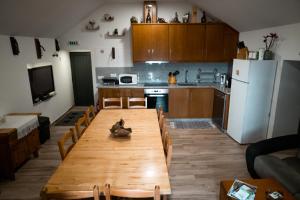 a kitchen with a wooden table with chairs and a refrigerator at Refúgio Nariz do Mundo (Casa do Meio) in Cabeceiras de Basto +43 photos