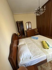 een slaapkamer met een bed met witte lakens en een kroonluchter bij Appartamento Marilyn in Levanto