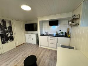 eine Küche mit weißen Schränken und einer Arbeitsplatte in der Unterkunft Mini apartment in centre of Jørpeland in Jørpeland