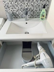a white bathroom sink with a vacuum under it at Piso en el corazón de Alicante in Alicante