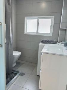 a white bathroom with a sink and a toilet at Piso en el corazón de Alicante in Alicante