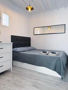 a bedroom with a bed and a dresser and a mirror at Piso en el corazón de Alicante in Alicante