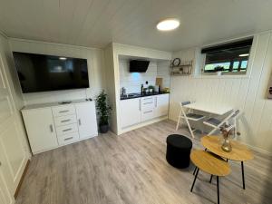 Zimmer mit einer Küche, einem Tisch und einem TV in der Unterkunft Mini apartment in centre of Jørpeland in Jørpeland
