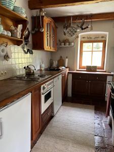 a kitchen with wooden cabinets and a white stove top oven at Forsthartl 7 Landhausurlaub in Steinbach