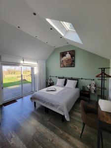 ein Schlafzimmer mit einem großen Bett und einem Fenster in der Unterkunft Les Embreoles in Clitourps