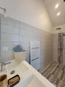 ein Bad mit einem Waschbecken und einer Dusche in der Unterkunft Les Embreoles in Clitourps