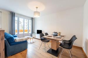 a living room with a table and a blue couch at ANNECY Centre - Charmant T2 in Annecy