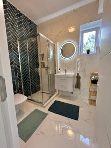 baño blanco con ducha y lavamanos en B-Home, en Göd