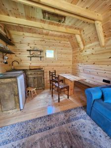 a log cabin living room with a table and a couch at Etno Villas Tara&Petra in Žabljak