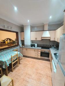 a large kitchen with white cabinets and a table at El Chivero in Fuengirola