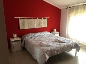 a bedroom with red walls and a bed and a window at B&B Daddanca in Ales