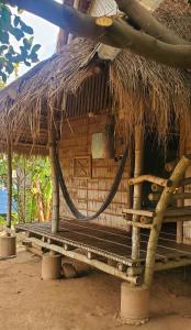 una cabaña con techo de paja encima en OBT - The Banana Bungalow 