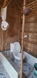 e bagno con servizi igienici su una parete in legno. di OBT - The Banana Bungalow 