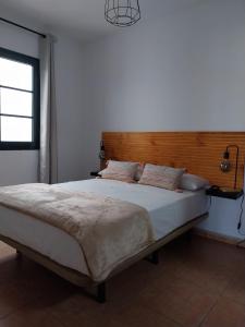 - une chambre avec un grand lit et une tête de lit en bois dans l'établissement Apartamento Stefi, à Arrecife
