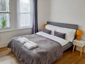 een slaapkamer met een groot bed en handdoeken bij 2 bedroom-2 mins walk to Station in Kent