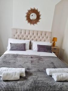 een slaapkamer met een groot bed en 2 handdoeken bij 2 bedroom-2 mins walk to Station in Kent