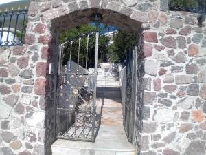 uma entrada para um edifício de pedra com um portão de ferro em Αίγινα εξοχική κατοικία em Aegenitissa