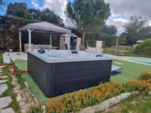 una bañera de hidromasaje en un patio con flores en Villa Pancorbo, en Velayos