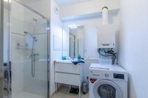 a bathroom with a washing machine and a shower at Appartement Cosy Rez de jardin in Bénerville-sur-Mer +8 photos