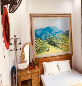 um quarto com uma pintura na parede ao lado de uma cama em Yen Minh Thien An Motel em Yên Minh