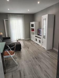 een woonkamer met een bed, een bank en een tv bij Nuevo Garcia Lorca in Cádiz