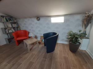 sala de estar con silla azul y silla roja en LA PASSIFLORE, en Azé