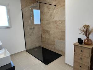 un bagno con doccia con porta in vetro di Gîte des couleurs avec SPA a Chicheboville Altre 23 foto