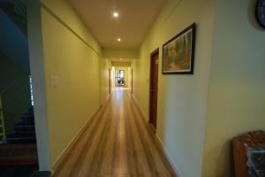 a hallway of a house with a wooden floor at golden residency Mysore in Mysore
