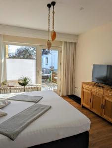 ein Schlafzimmer mit einem Bett und einem Flachbildfernseher in der Unterkunft Haus Grünewald Unsleben in Unsleben + 37 Fotos