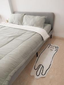 a bed with a drawing of a cat on it at Gold Coast Apartment PIK Lovely Stay Near Airport in Jakarta