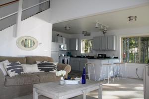 un soggiorno e una cucina con divano e tavolo di Sunset Cove Cottage private beach a Prospect Harbor