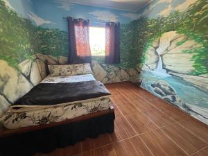 - une chambre avec un lit orné d'une peinture murale dans l'établissement Sitio da Mata, à São Thomé das Letras
