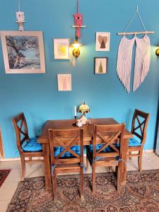 a dining room table with two chairs and a blue wall at Oberża Pod Kudłatym Aniołem in Cisna