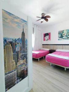 a room with two pink beds and a city at velazquez aeropuerto in Málaga