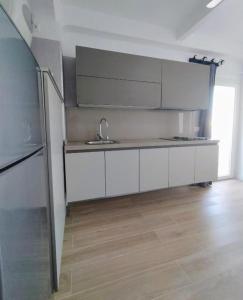 a kitchen with white cabinets and a sink at velazquez aeropuerto in Málaga