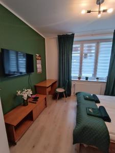 1 dormitorio con 1 cama, escritorio y TV en Jackowskiego Zielony en Poznan