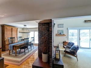 a living room and dining room with a brick wall at Oceanfront Crackling Cove Cottage NEW in Prospect Harbor