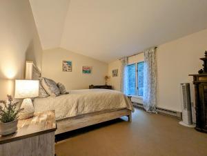 - une chambre avec un grand lit et une fenêtre dans l'établissement Oceanfront Crackling Cove Cottage NEW, à Prospect Harbor