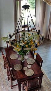 une table en bois avec un vase de fleurs. dans l'établissement Siedlisko Barnabówka, à Wydminy