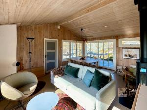 a living room with a couch and a table at Idyllic Cabin in Lillesand fantastic ocean view in Lillesand