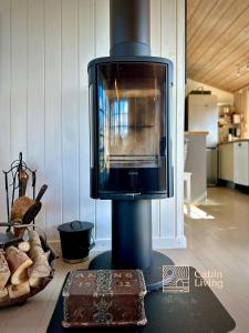 a microwave sitting on top of a stove in a room at Idyllic Cabin in Lillesand fantastic ocean view in Lillesand