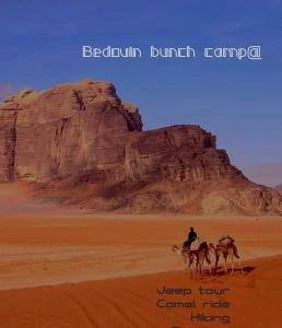 a man riding a camel in the desert at Bedouin Bunch Camp in Wadi Rum