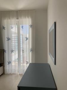 um quarto com uma mesa em frente a uma janela em La Fanciulla - Rooftop Apartment em Leuca