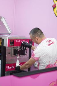 un hombre está usando una máquina en una tienda en Dendi Plaza Hotel, en Bukhara