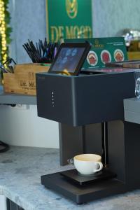 uma máquina de café com uma chávena no balcão em Dendi Plaza Hotel em Bukhara